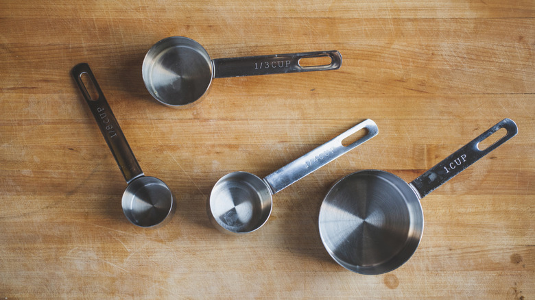 Metal measuring cups on a wooden surface