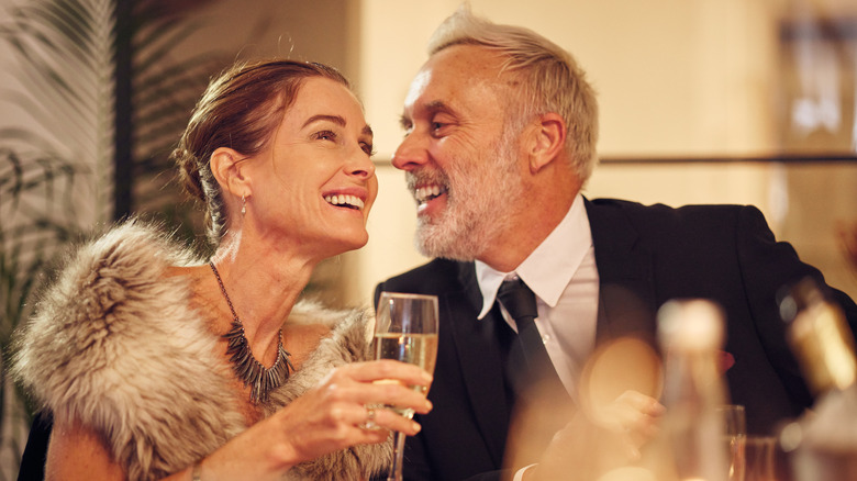 A happy, well-dressed couple enjoying drinks