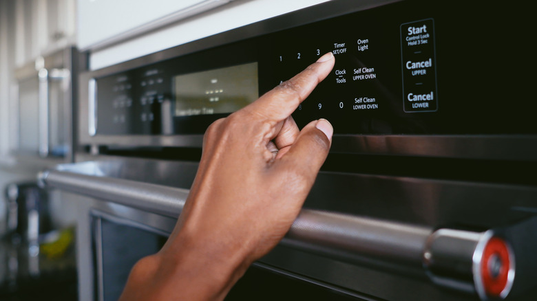 Someone setting the temperature on an oven