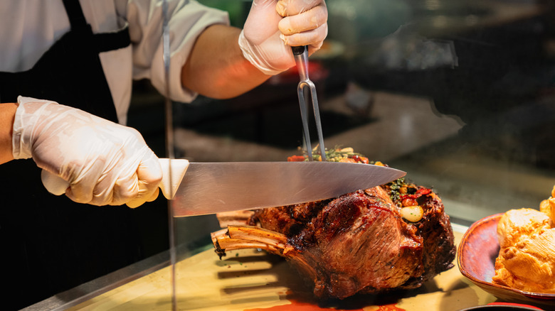 A chef slicing a prime rib at a carving station