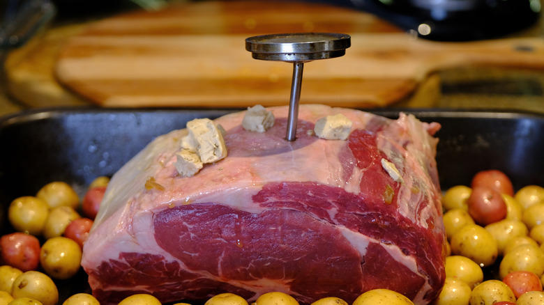 Prime roast with a meat thermometer, surround by baby potatoes