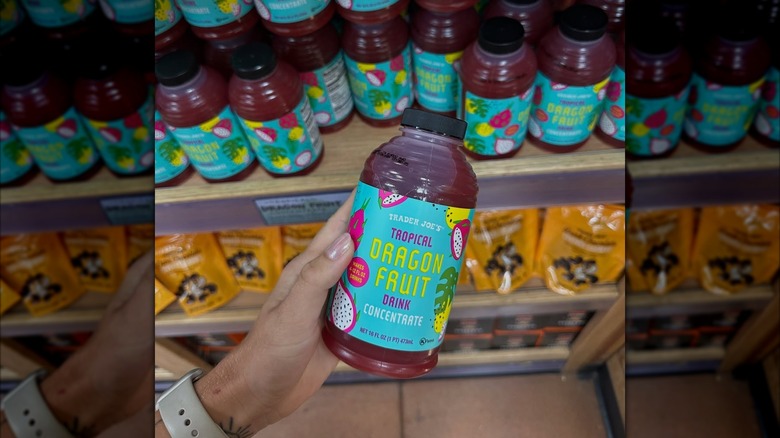 a person holding a Trader Joe's drink made with dragon fruit