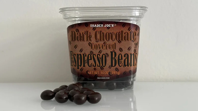Container of chocolate-covered espresso beans on a white counter