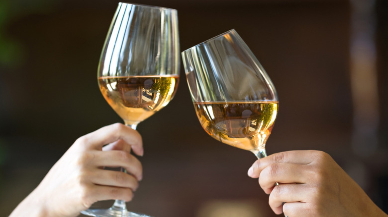 People touching their white wine glasses together