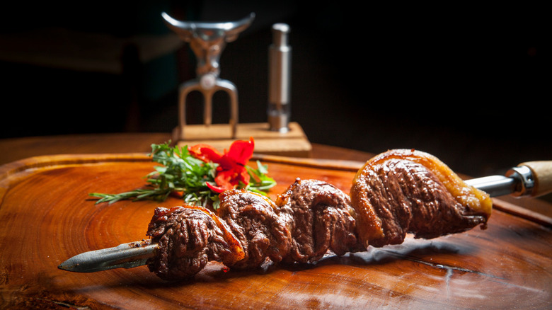 Picanha, straight from the skewer, on a table.