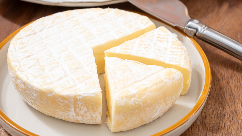 round wheel of brie cheese with slices cut into it