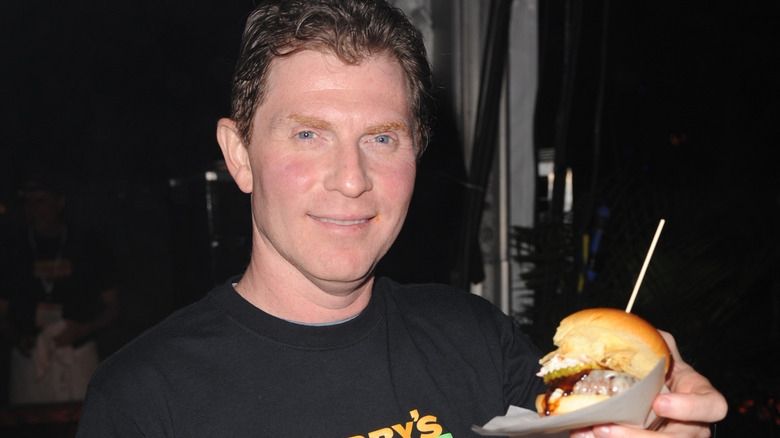 Bobby Flay holding up a burger