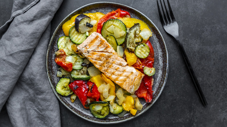 A plate of cooked salmon and vegetables