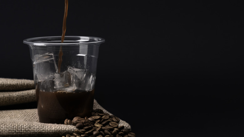 Cup of iced coffee being poured