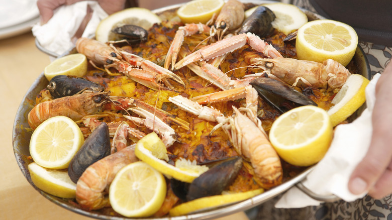 Plate of seafood paella with shellfish and lemons
