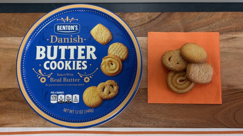 Benton's Danish Butter Cookie tin next to four cookies on orange napkin