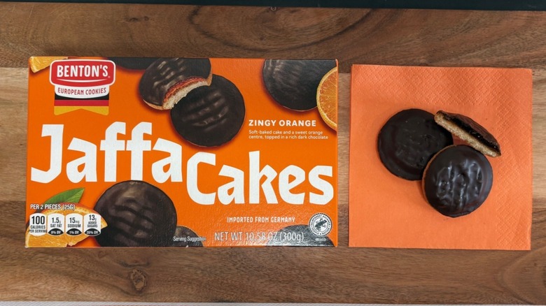 Benton's Jaffa Cakes package next to two cookies on orange napkin