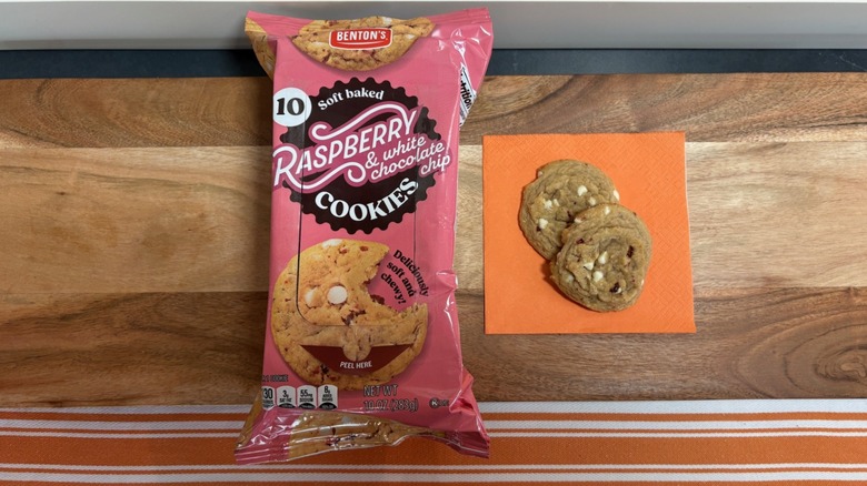 Benton's Soft Baked Rspberry Cookie next to two cookies on orange napkin
