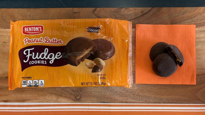 Benton's Peanut Butter Fudge Cookie package next to three cookies on orange napkin