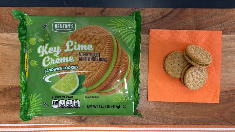 Benton's Key Lime Creme Cookie package next to three cookies on orange napkin