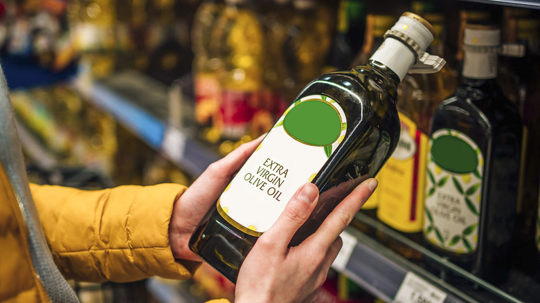 Hands holding bottle of olive oil