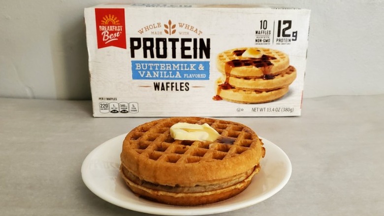Breakfast Best buttermilk and vanilla protein waffles with butter and syrup on a small white plate in front of the package