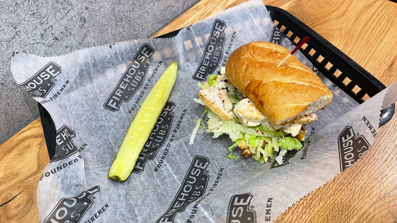 Firehouse Captain's Club and dill pickle spear in a black basket on wooden table