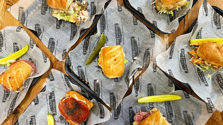 Several sandwiches from Firehouse Subs laid out over a wooden table