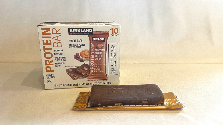 Unwrapped Chocolate Peanut Butter Chunk Protein Bar beside its packaging