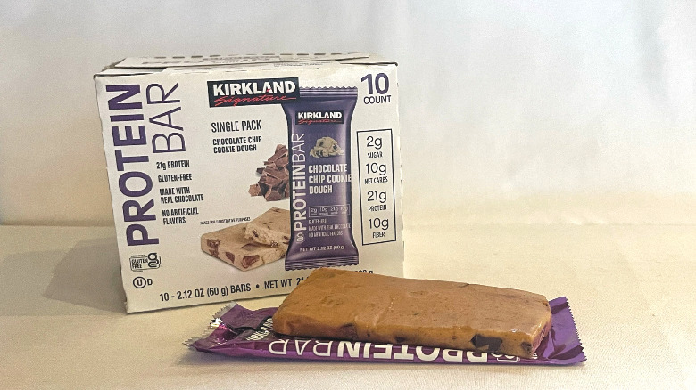Unwrapped Chocolate Chip Cookie Dough Protein Bar beside its packaging
