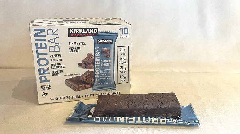 Unwrapped Chocolate Brownie Protein Bar beside its packaging