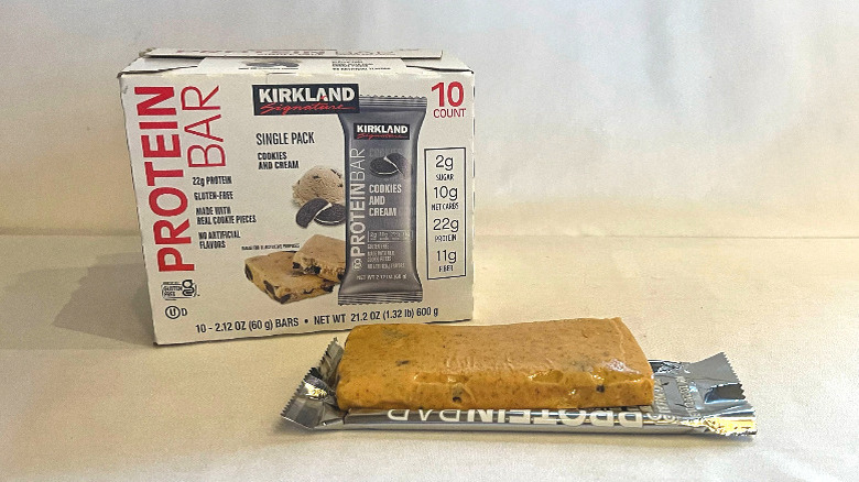 Unwrapped Cookies and Cream Protein Bar beside its packaging