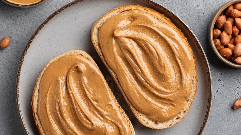 Two slices of toast with peanut butter on a plate