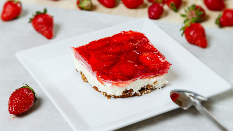 A slice of strawberry pretzel salad on a white plate.