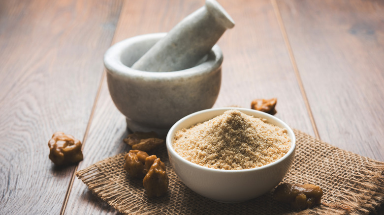 Asafetida with mortar and pestle and gum on wood table