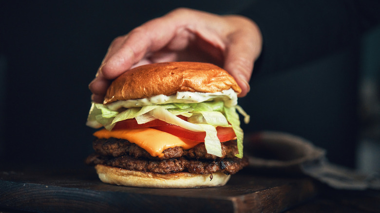 Hand on top of burger