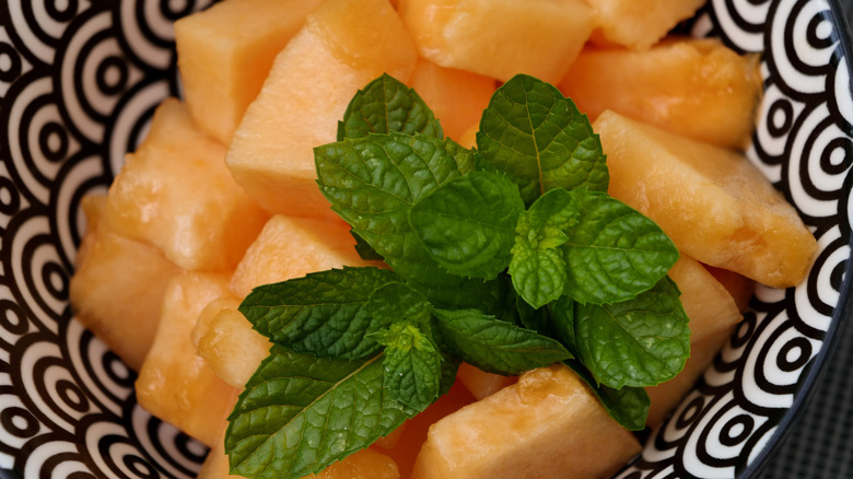 Diced cantaloupe pieces with fresh green mint