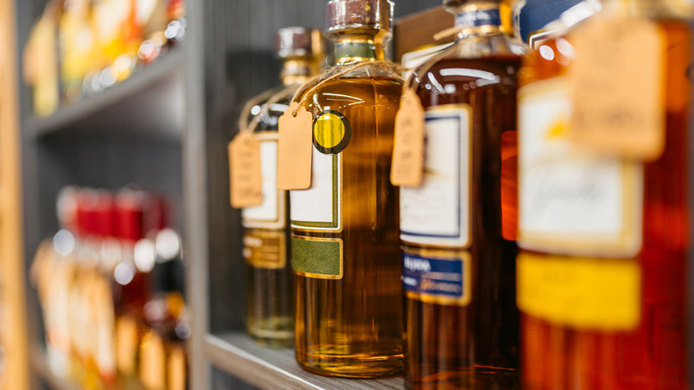 Liquor bottles line a store shelf.