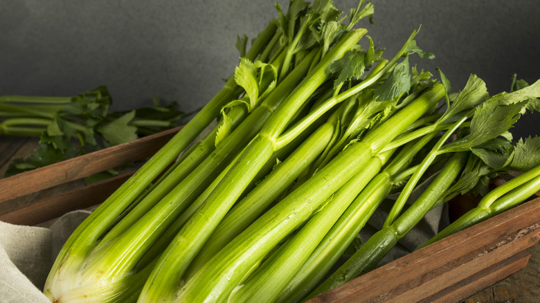 Celery bunches in a wooden container.