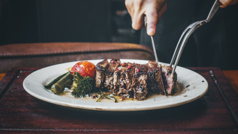 Person cutting into a caramelized steak