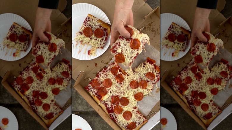Hand picking up a slice of Ohio Valley-style pizza