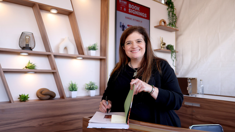 Chef Alex Guarnaschelli smiling at a book signing.