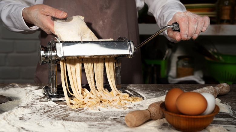 Person hand-cranks a pasta machine