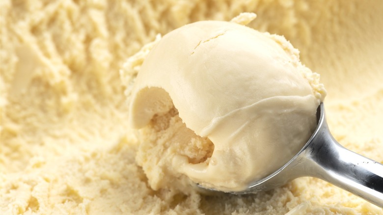 Scooping vanilla ice cream from container