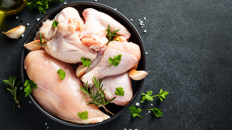 Raw chicken with herbs in a bowl