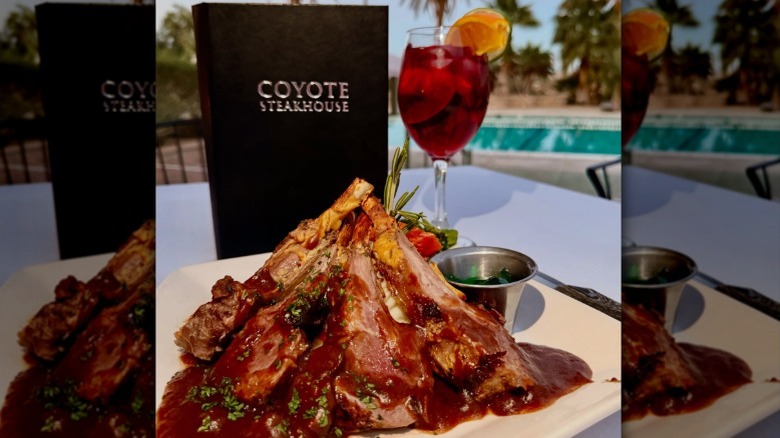 Coyote Steakhouse menu next to a glass of sangria and a plate of pork chops