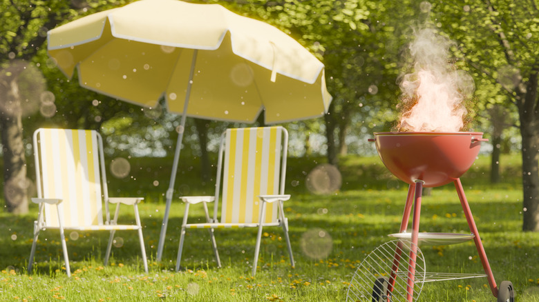 Retro style lawn chairs and umbrellas next to a pink retro grill