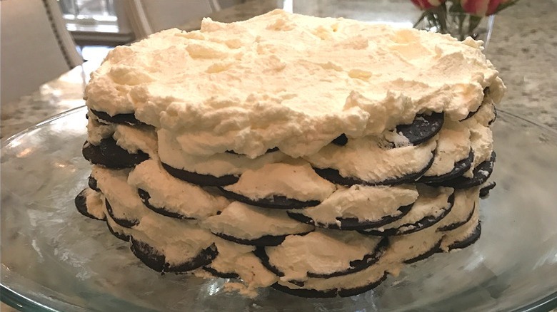 Close up of homemade round icebox cake with layers of cookies and whipped cream.