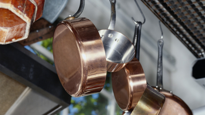 Pans hooked onto a hanging pot rack.