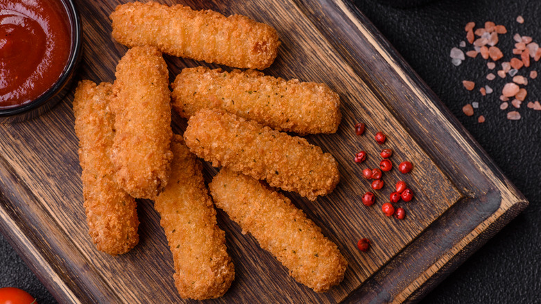Fried mozzarella sticks on a wooden board