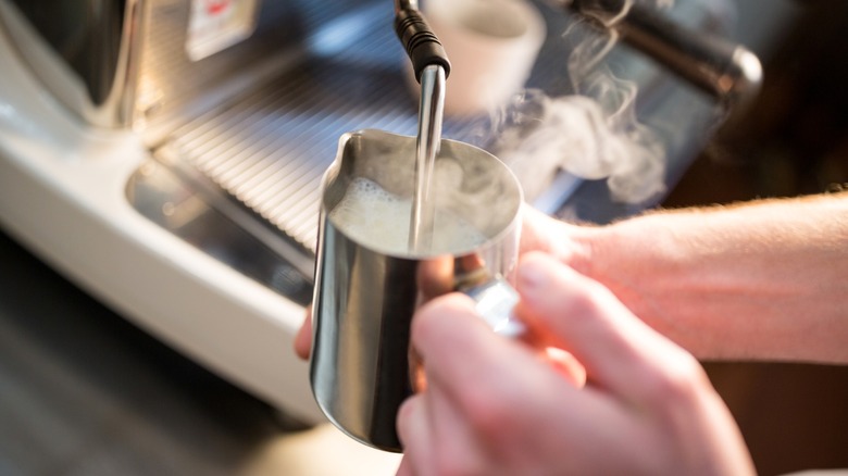 Person steaming milk