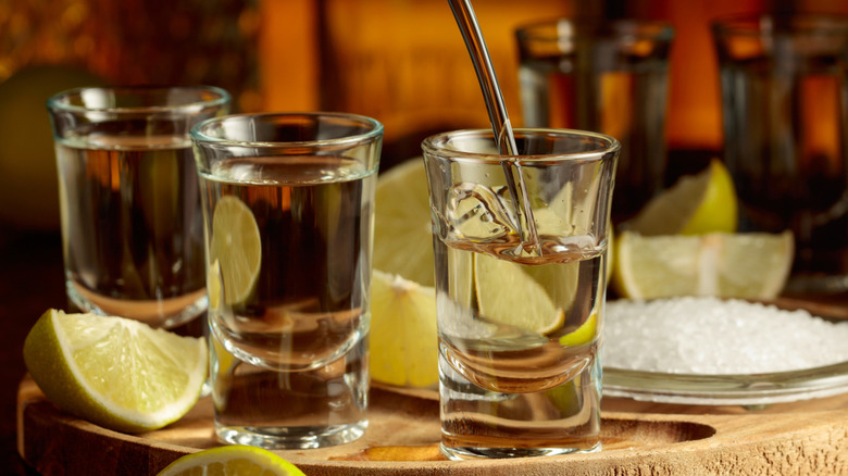 Tequila being poured into shot glasses