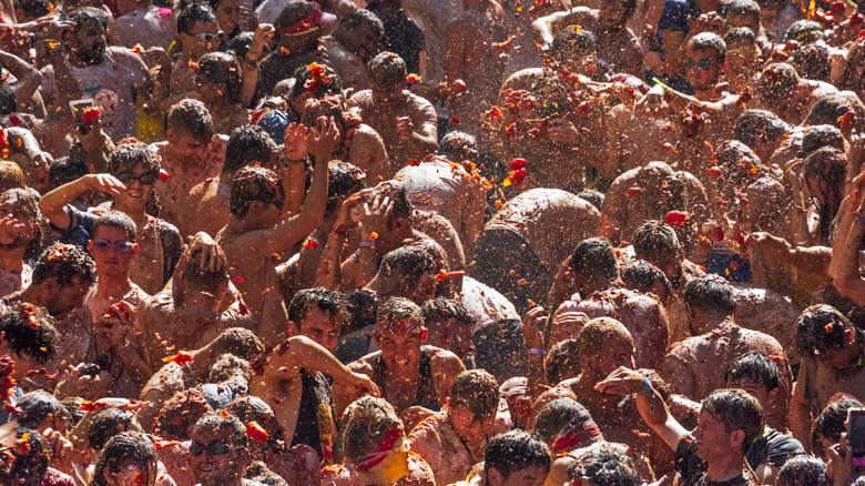 Attendees at La Tomatina throwing tomatoes at each other.