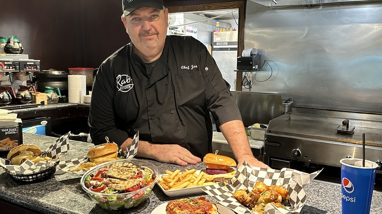 Chef Joe standing behind the counter at Rab's with various food items in front of him