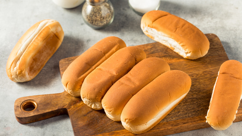 Hot dog buns on a wooden board